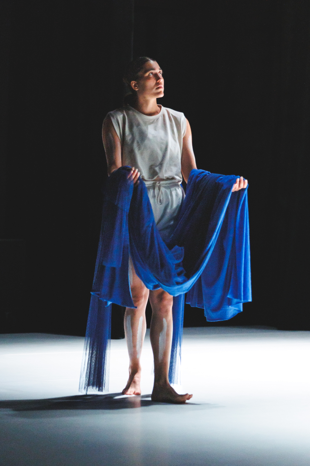 La danseuse Lea Anderson porte un linceul bleu dans ses bras, création lumière de Jérôme Baudouin, créateur lumière en danse, théâtre et spectacle vivant